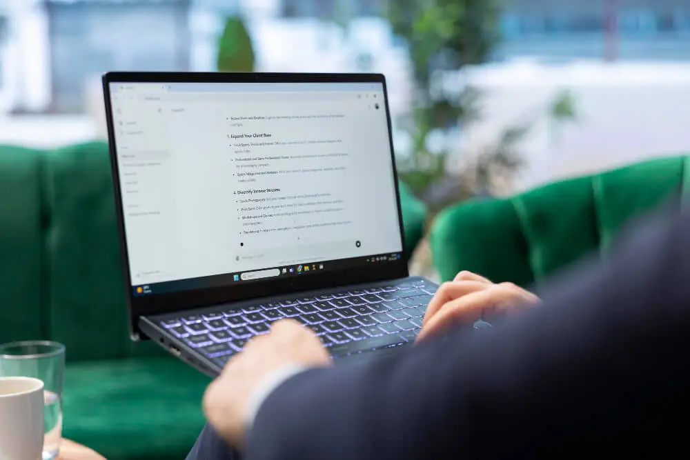 Student using ChatGPT for homework on laptop at modern desk with blue lighting