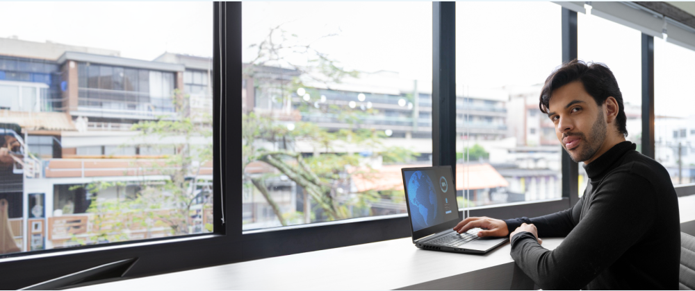 Small business owner in a modern blue-lit office reviewing an AI agent dashboard on a laptop